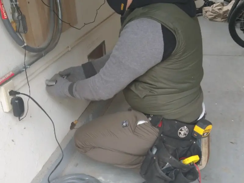 Electrician performing outlet wiring in a Redlands garage